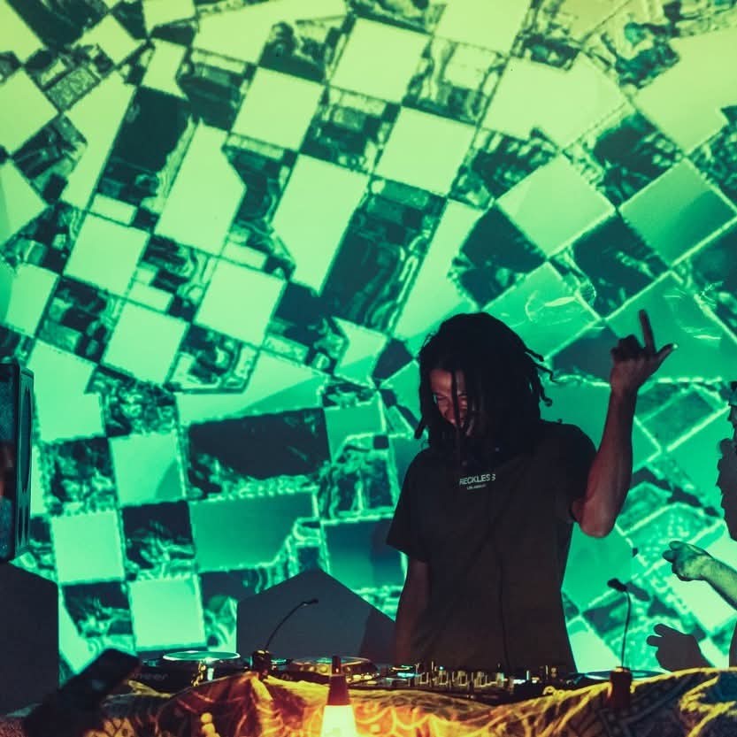 SCVRVB performing with vibrant green geometric visual projections